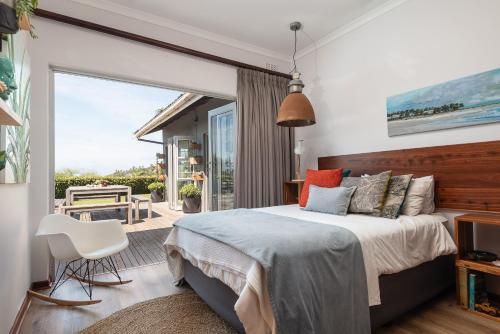a bedroom with a large bed and a balcony at Fords on Fairway in Sheffield Beach