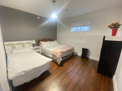 a small room with two beds and a window at lovely home in Calgary