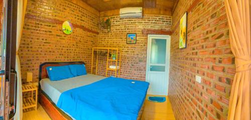 a small room with a bed in a brick wall at D&D riverside Homestay in Xuân Sơn