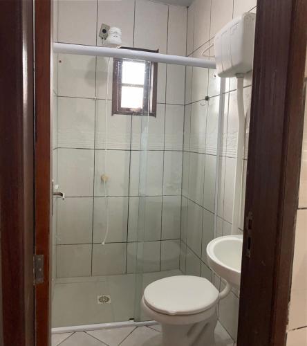 a bathroom with a toilet and a shower and a sink at Casa para temporada, Florianópolis in Florianópolis