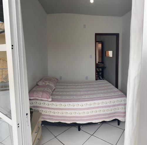 a small bedroom with a bed in a room at Casa para temporada, Florianópolis in Florianópolis