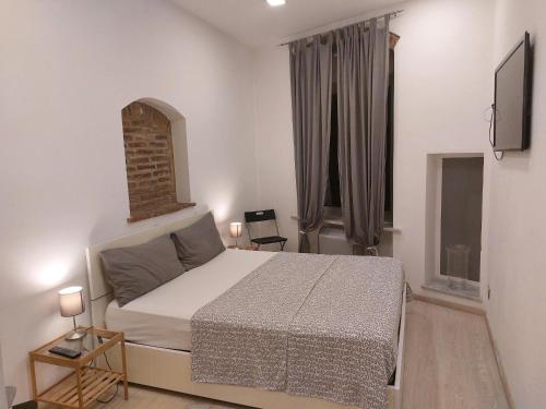 1 dormitorio con 1 cama y TV en Piazzetta dei Consoli Apartment, en Savona