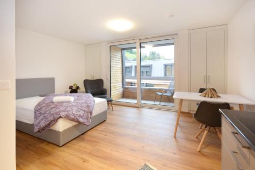 a bedroom with a bed and a desk and a window at Bären Herisau GmbH in Herisau