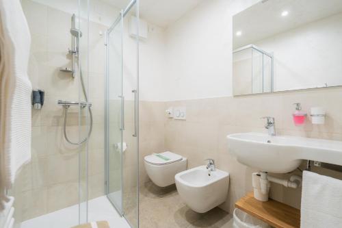 y baño con ducha, lavabo y aseo. en Hotel Panorama, en San Martino di Castrozza