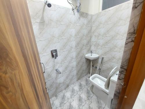 a bathroom with a toilet and a sink at HOMEWOOD SUITES Near Jaipur Airport in Jaipur