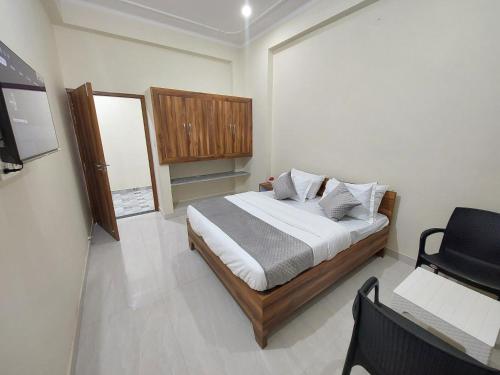 a bedroom with a bed and a chair in it at HOMEWOOD SUITES in Jaipur