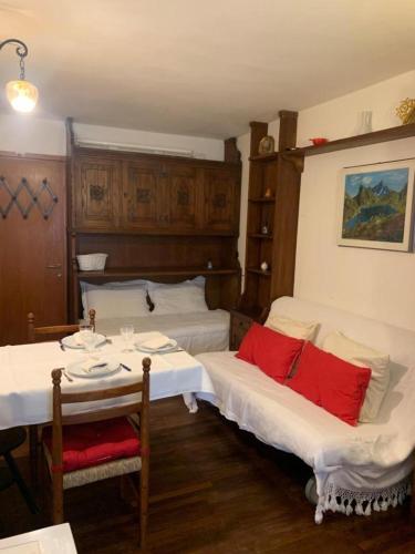 um quarto com duas camas e uma mesa com almofadas vermelhas em Casa Neve em Sestriere