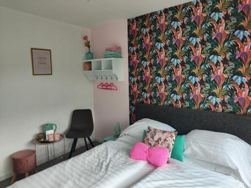 een slaapkamer met een bed met roze wanten erop bij Hotel B&B LeLa in Valkenburg