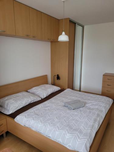 una camera da letto con un grande letto con lenzuola bianche di Apartmán Neva Trnava a Trnava