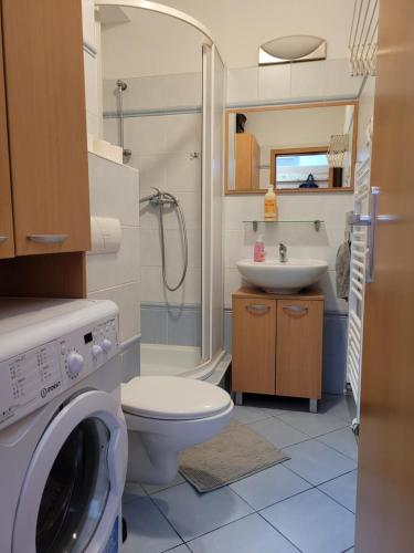 a bathroom with a washing machine and a sink at Apartmán Neva Trnava in Trnava