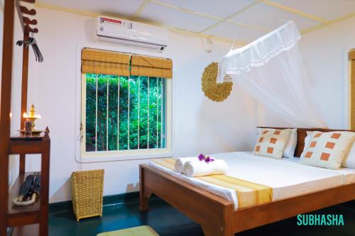 a bedroom with a bed and a window at Subhasha Summer House in Talalla
