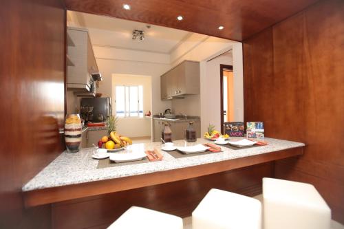 a kitchen with a counter with plates of fruit on it at Apparthotel Eden Beach in Taghazout