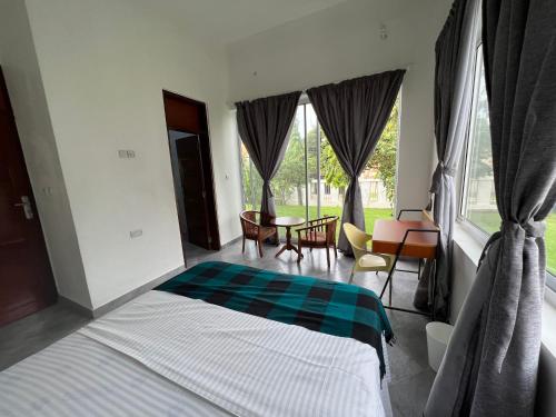 una camera con letto, tavolo e finestre di Datela Home - 3Bed Villa near Ununio Beach Kunduchi a Dar es Salaam