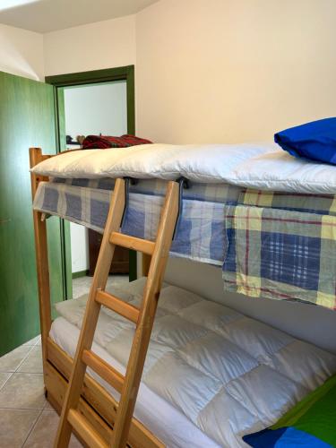 two bunk beds in a room with a ladder at Casa Francesca in Ponte di Legno