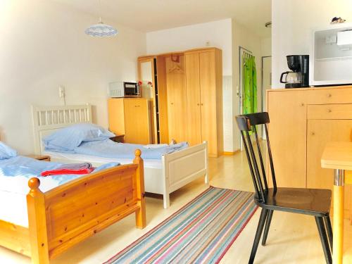 um quarto com 2 camas, uma mesa e uma cadeira em Gästezimmer Rothneusiedl em Viena