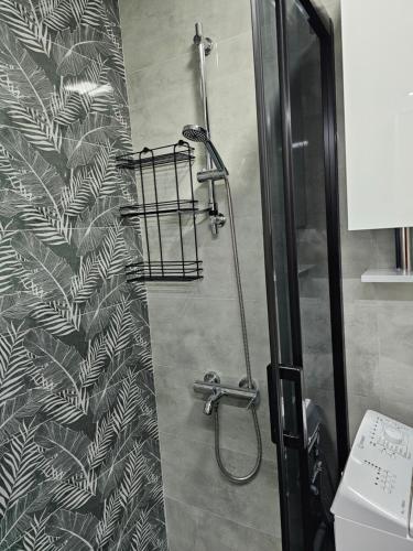 een douche in een badkamer met zwart-wit behang bij Unique apartment in the old part in Ohrid