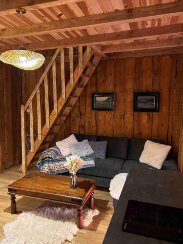 un salon avec un canapé et une table dans l'établissement Gîte La Forêt du Domaine des Aguilès, à Nistos