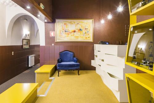a waiting room with a blue chair and a painting at Costa do Sol B&B in Porto