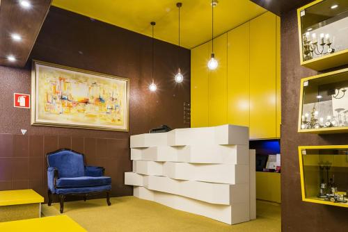 a waiting room with a blue chair and a pile of boxes at Costa do Sol B&B in Porto