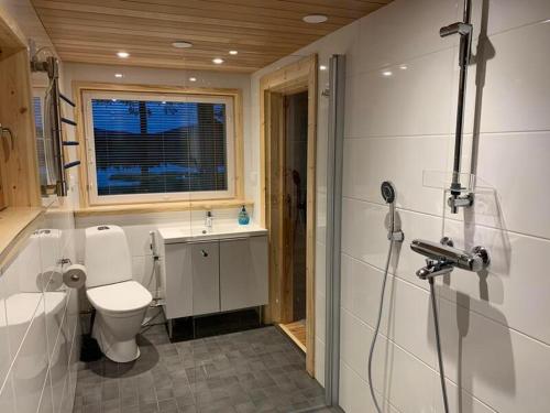 a bathroom with a toilet and a shower in it at Kaupinmaja, Ylläs - Hirsimökki järvi- ja tunturimaisemilla in Äkäslompolo