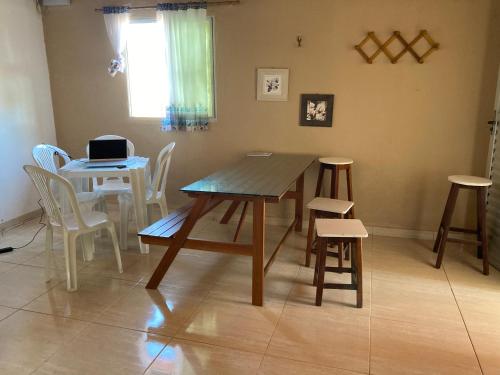 a dining room with a table and chairs and a laptop at Pousada Vitória in Pitimbu