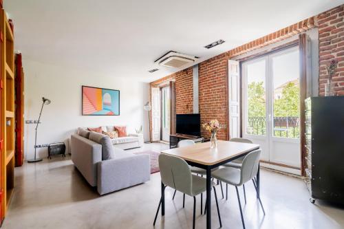 a living room with a table and chairs and a couch at apartamento reformado estilo industrial plaza de tirso de molina in Madrid