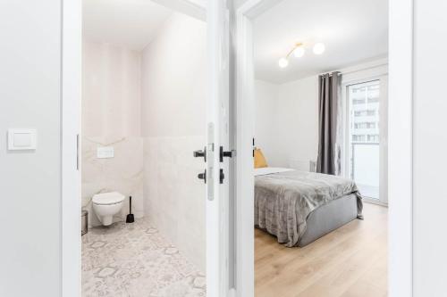 a white bedroom with a bed and a toilet at Enjoy! Ursus in Warsaw