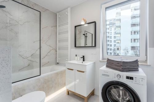a white bathroom with a washing machine in it at Enjoy! Ursus in Warsaw