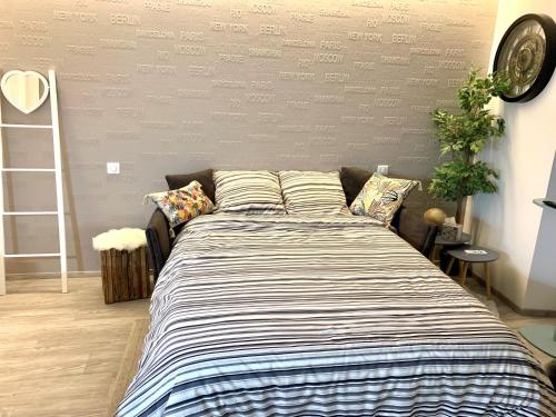 Ce lit se trouve dans un dortoir doté d'une couverture rayée. dans l'établissement Le coin 45, à Colmar