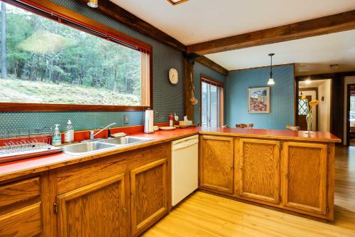 グランツパスにあるPeaceful Applegate River Valley Sanctuary!のキッチン(木製キャビネット付)、大きな窓が備わります。