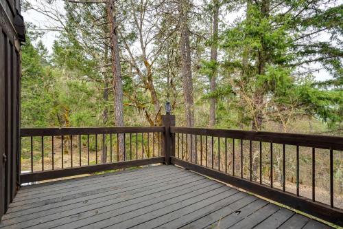 a wooden porch with a fence and trees at Peaceful Applegate River Valley Sanctuary! in Grants Pass