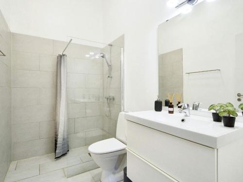 a white bathroom with a toilet and a shower at Holiday home Gilleleje CVII in Gilleleje