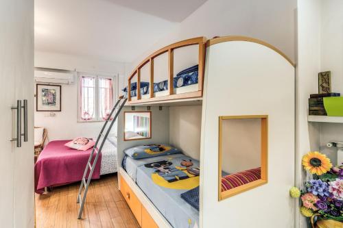 Zimmer mit 2 Etagenbetten und einem Spiegel in der Unterkunft SUNSET SUMMER HOUSE in Passoscuro
