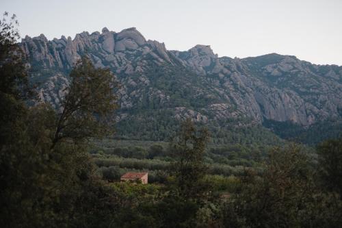 a small house in front of a mountain at Hotel-Masia Can Farrés in El Bruc