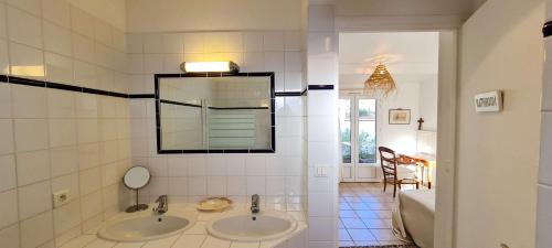 ein Badezimmer mit zwei Waschbecken und einem Spiegel in der Unterkunft Charmante villa avec piscine in La Couarde-sur-Mer