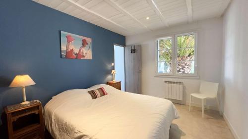 - une chambre avec un lit blanc et un mur bleu dans l'établissement Superbe villa proche de la mer, à Sainte-Marie de Ré