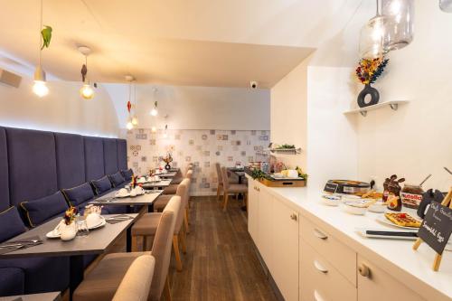 un restaurant avec de longues tables et des chaises bleues dans l'établissement Hôtel La Parizienne, à Paris