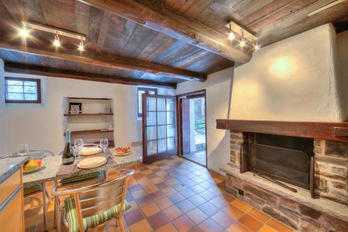 a kitchen with a table and a fireplace at Rustico Caterina - Happy Rentals in Corippo