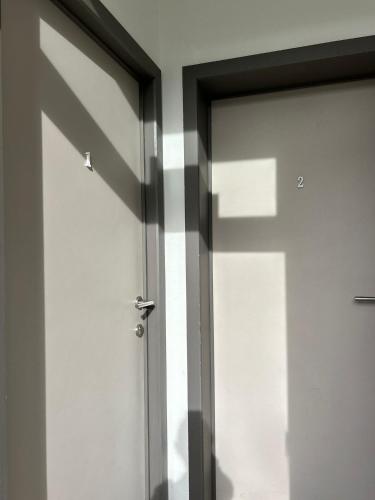 a sliding glass door with a shadow on a wall at Les petits nids de Nina 1 in Fosses-La-Ville
