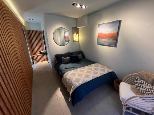 a small bedroom with a bed and a mirror at The Coachhouse, Hot Tub in Henley in Arden