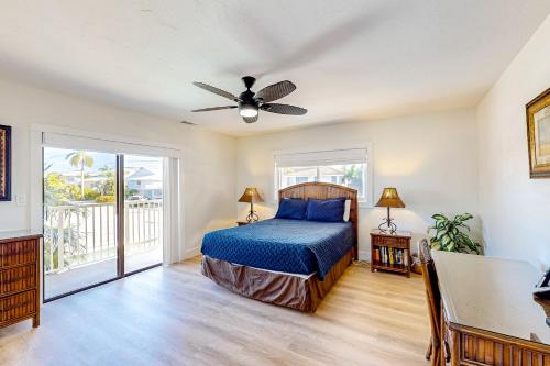 a bedroom with a bed and a ceiling fan at Canal-side Charisma in Key Colony Beach