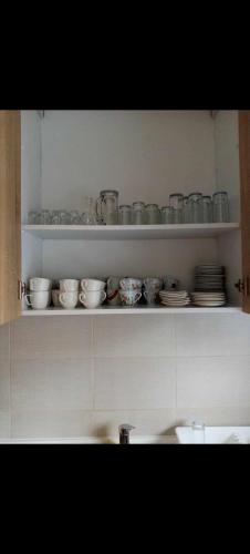 a kitchen shelf with dishes and bowls on it at Vikendica Rosi 