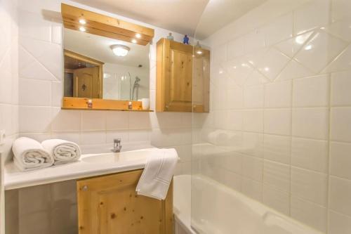 Un baño con lavabo, bañera y espejo. en Le Jardin d'Hiver - Appartement chaleureux avec beaucoup de charme, en Les Allues