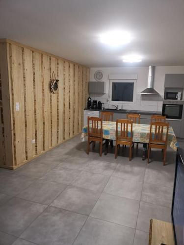 une cuisine et une salle à manger avec une table et des chaises dans l'établissement Belle appartement style chalet, à Gérardmer