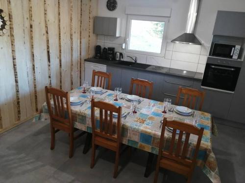 une cuisine avec une table, des chaises et une nappe dans l'établissement Belle appartement style chalet, à Gérardmer