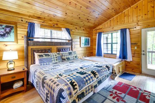 ein Schlafzimmer mit einem Bett in einer Holzhütte in der Unterkunft Tennessee Cabin with Balcony, Hot Tub and Pool Access! in Sevierville