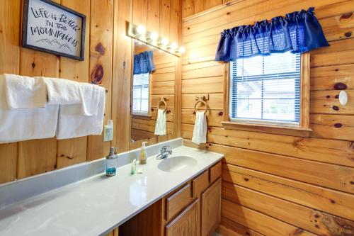 ein Bad mit einem Waschbecken und einem Spiegel in der Unterkunft Tennessee Cabin with Balcony, Hot Tub and Pool Access! in Sevierville
