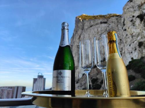Twee flessen champagne en twee glazen op een tafel. bij Luxury Apartment/High Floor/Stunning Views/Parking in Gibraltar