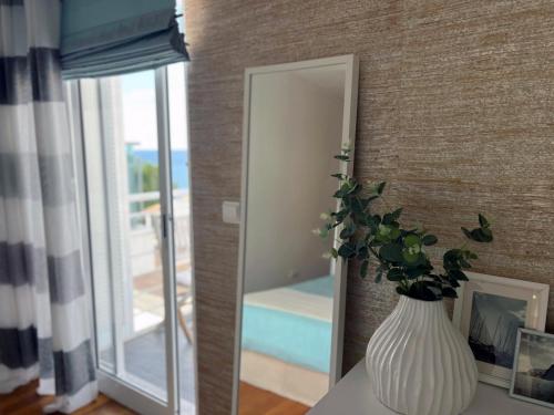 eine Vase mit einer Pflanze auf einem Tisch vor einem Spiegel in der Unterkunft Marias sea cottage in Funchal