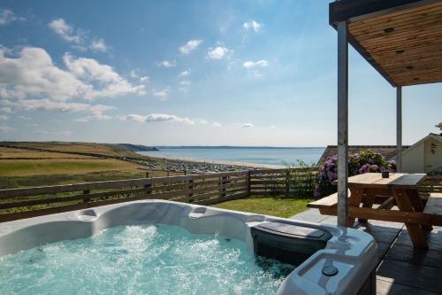 a hot tub on a patio with a view of the ocean at Unforgettable sea views, Hot tub, Modern property in Newgale